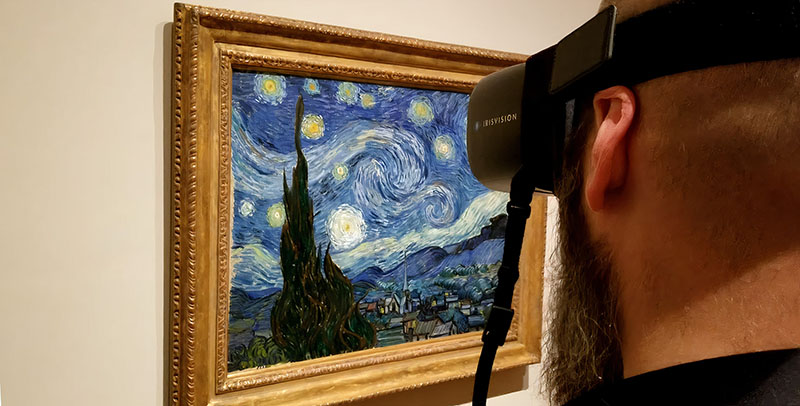 Sam from The Blind Life using wearable low vision glasses by IrisVision to look at The Starry Night painting by Van Gogh at the Museum of Modern Art located in New York. Sam from The Blind Life using wearable low vision glasses by IrisVision to look at The Starry Night painting by Van Gogh at the Museum of Modern Art located in New York.